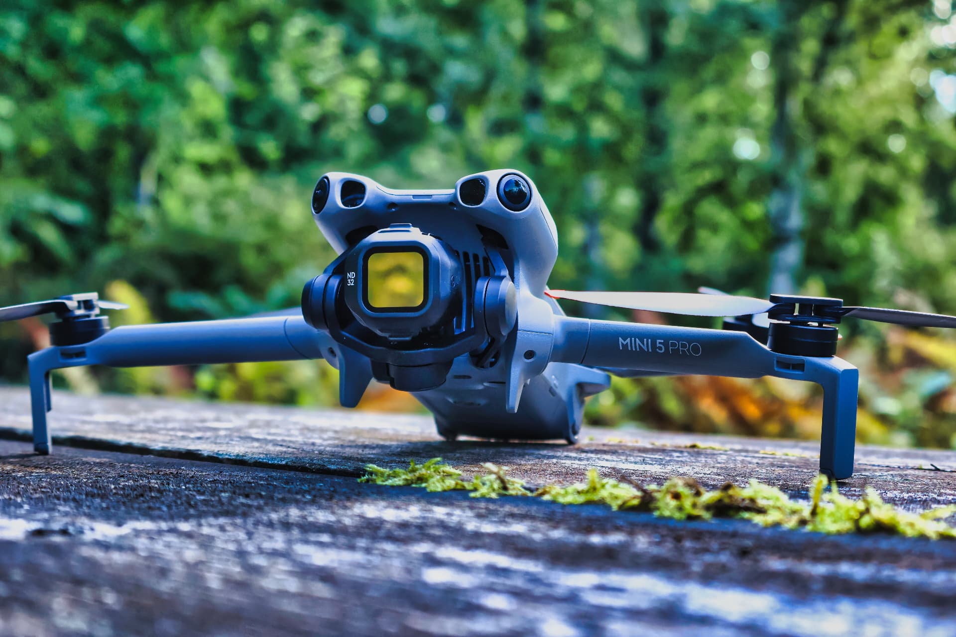 DJI-drone plassert på mosekledd trestubbe i skogen før droneoppdrag
